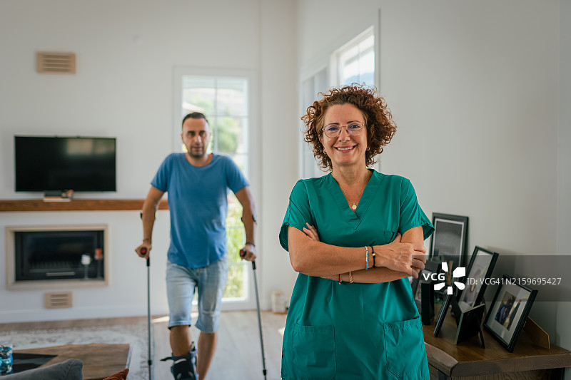 护士在家中帮助年轻男子进行物理治疗图片素材