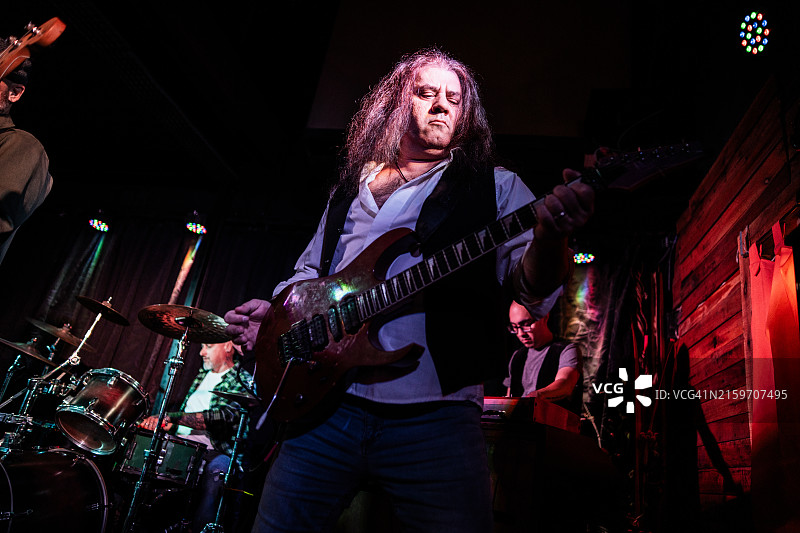 中年男人在舞台上弹电吉他图片素材