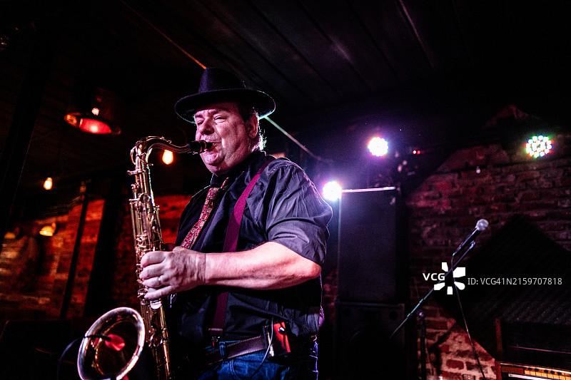 在夜总会演奏萨克斯管的年长音乐家图片素材