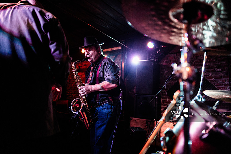 在夜总会演奏萨克斯管的音乐家图片素材