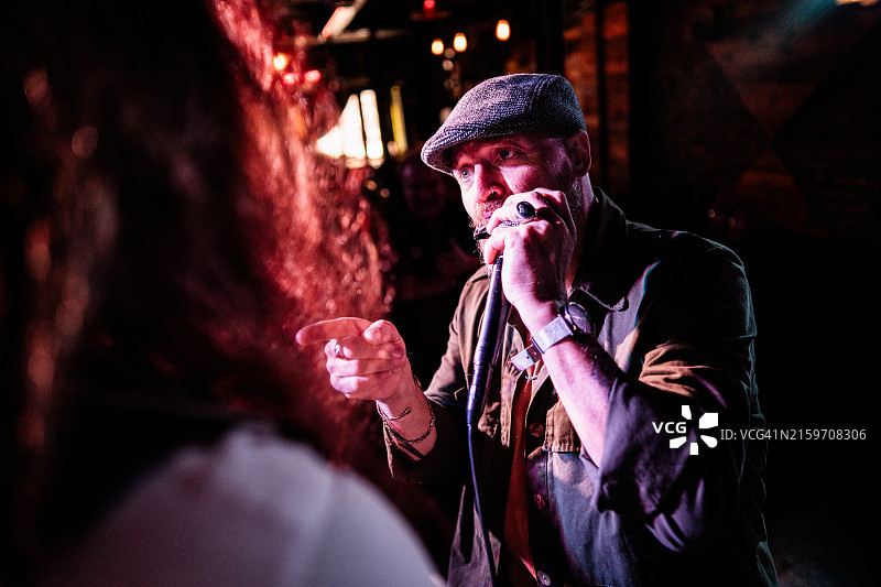 中年男人在现场音乐会上演奏口琴图片素材