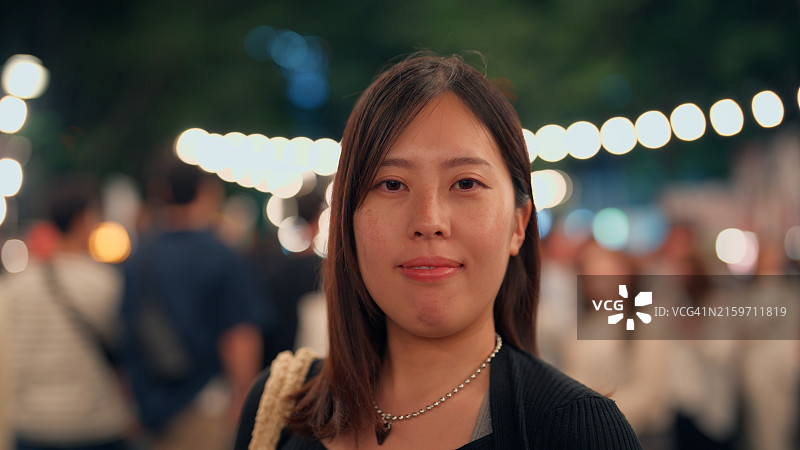在户外夜市和夜间节日上的亚洲妇女肖像图片素材