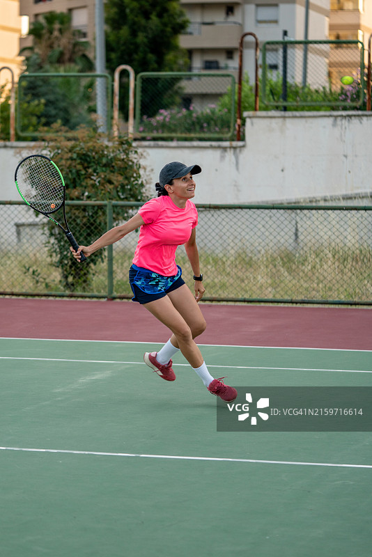 女子网球运动员跑向空中的球的竖版照片图片素材