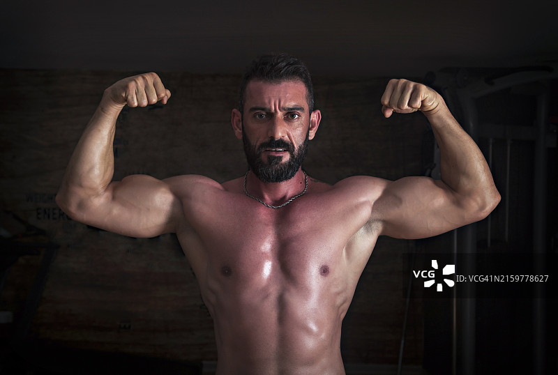 在健身房摆姿势的健美运动员图片素材