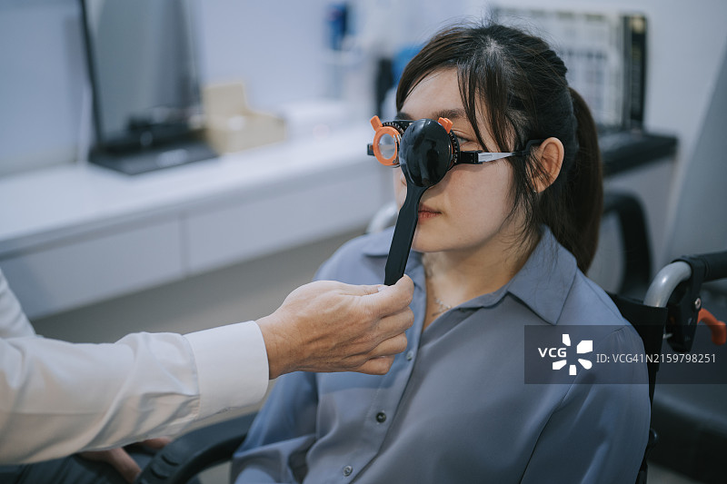 亚洲医生在诊所使用光学视力测试向量图为残疾女患者进行眼科检查图片素材