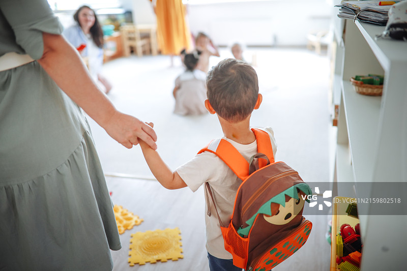 在幼儿园，背着书包的亚洲幼儿和妈妈开始适应儿童群体图片素材