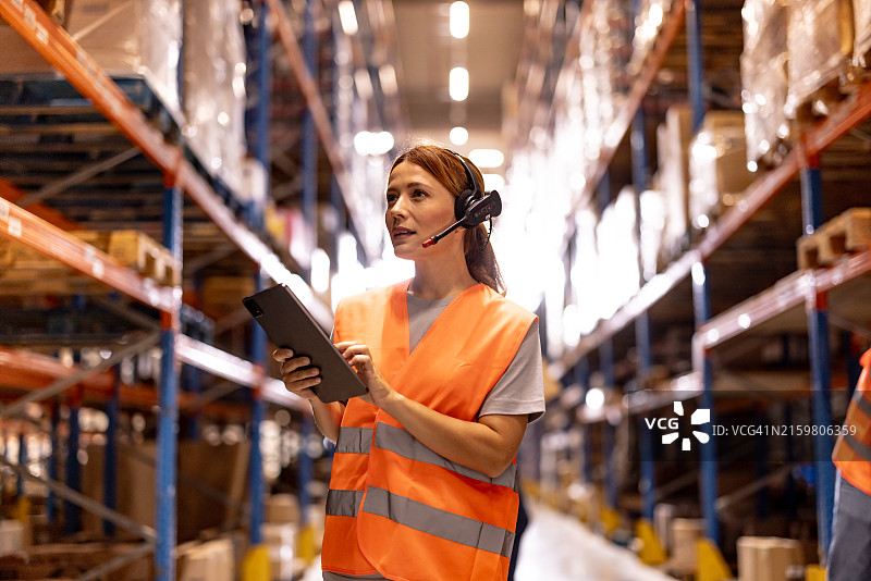 配送仓库工人使用平板电脑检查货架库存图片素材