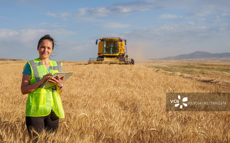 女农民在农田里拿着一个数位平板电脑，智慧农业图片素材