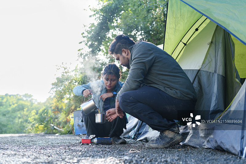 两个年轻朋友在帐篷旁喝茶图片素材