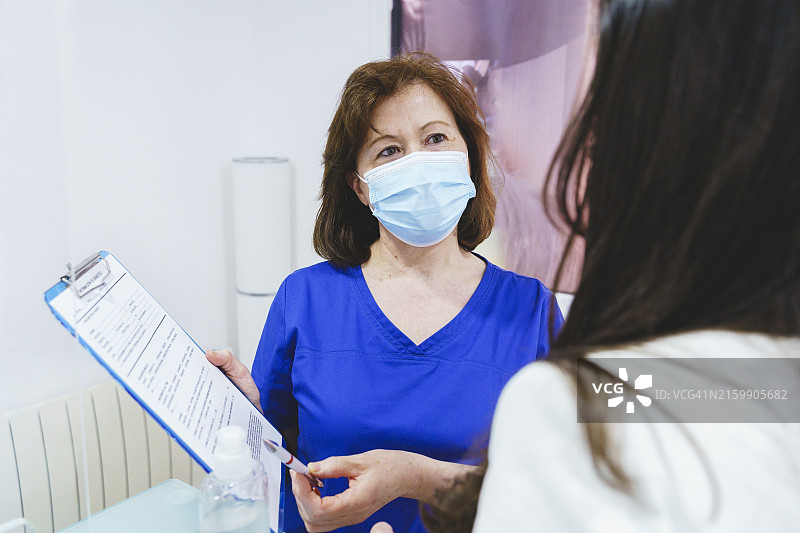 在诊所填写数据保护文件的年长医护人员肖像图片素材