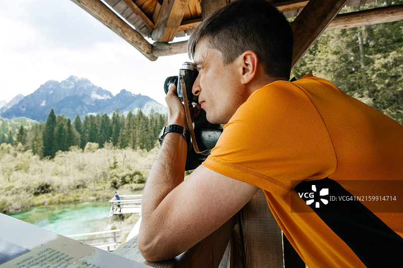 男子用复古胶片相机拍摄风景图片素材