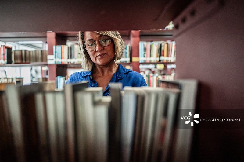 一个在图书馆找书的女人图片素材