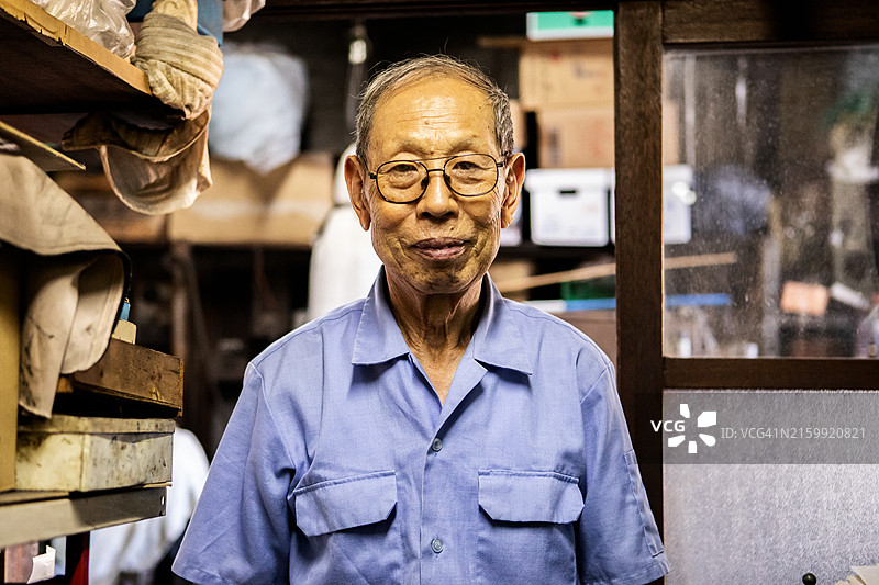年长的工匠在市区的一家金属加工店工作图片素材