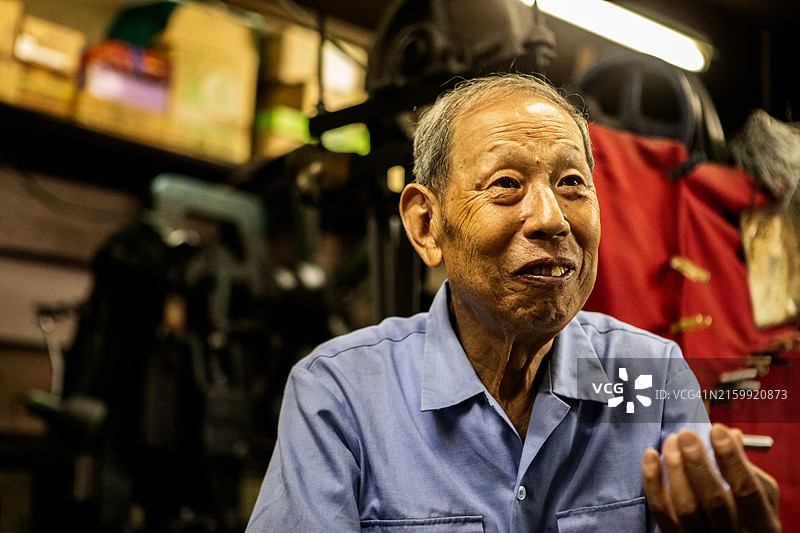 年长的工匠在市区的一家金属加工店工作图片素材