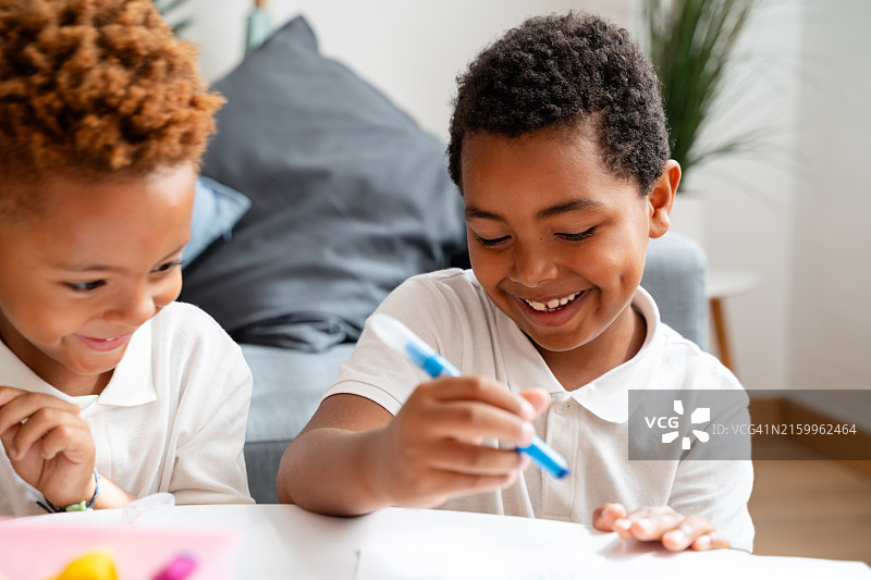 美术课上一起绘画的两个小学生图片素材