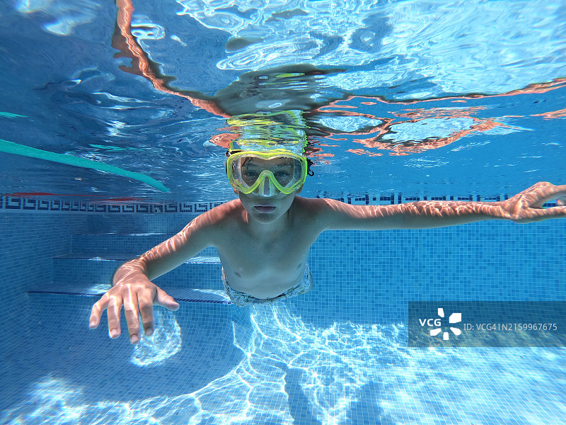 男孩在泳池潜水的水下镜头图片素材