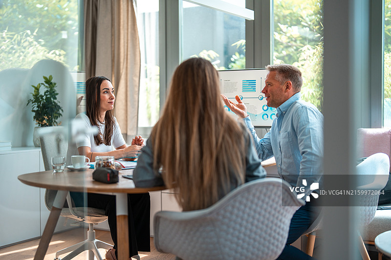 中年商业人士在会议中分析图表图片素材