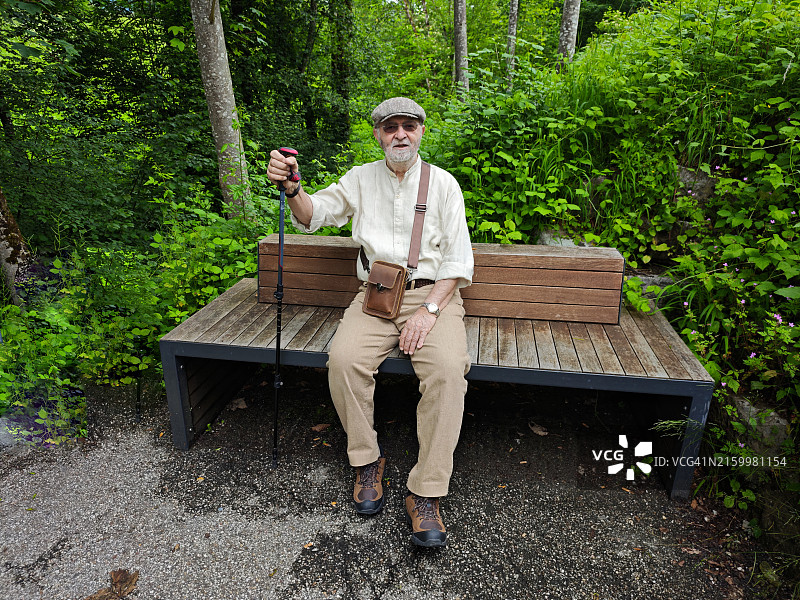 戴着帽子和手杖的老年人在贝希特斯加登阿尔卑斯山国家公园休息，德国巴伐利亚图片素材