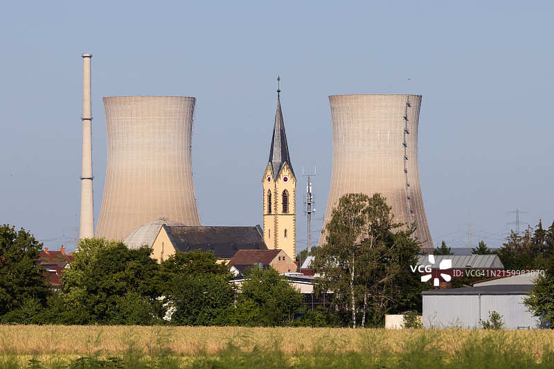 德国传统教堂尖顶与格拉芬莱茵费尔德核电站的冷却塔图片素材