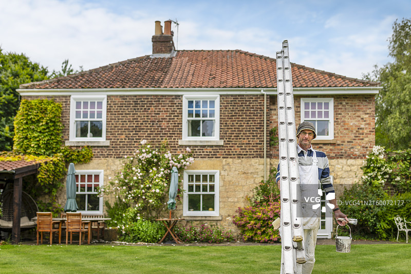 房屋前的油漆工与梯子、刷子和油漆罐图片素材