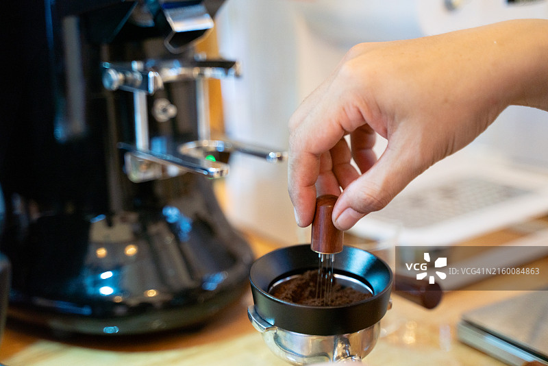 一个人用手持研磨器研磨咖啡豆图片素材