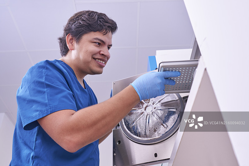 使用高压灭菌器对医疗材料进行消毒的哥伦比亚医生进行毛囊移植图片素材