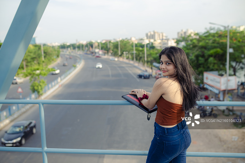 年轻漂亮的印度女学生，带着学习材料的肖像图片素材