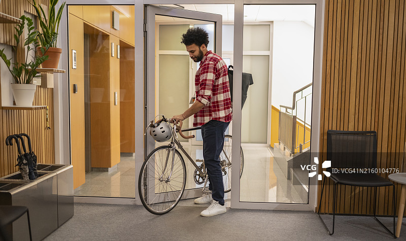 商人骑自行车进入办公室图片素材