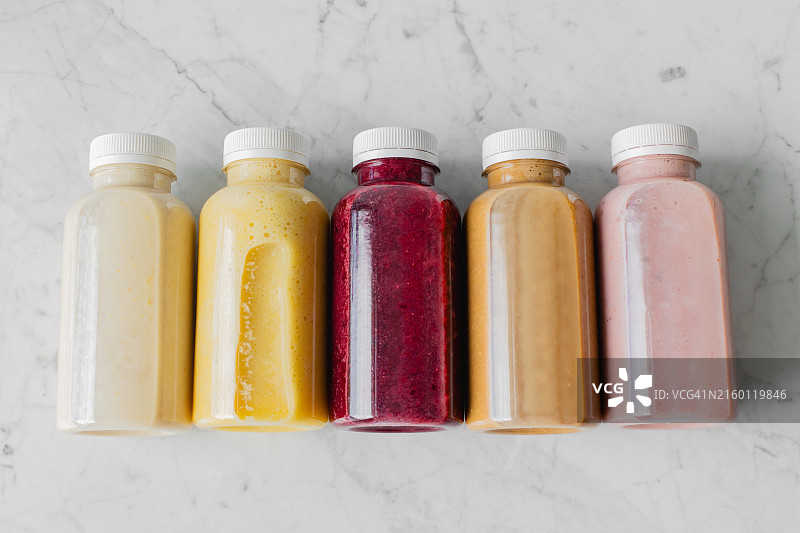 大理石桌上生态塑料瓶装浆果水果冰沙饮品图片素材