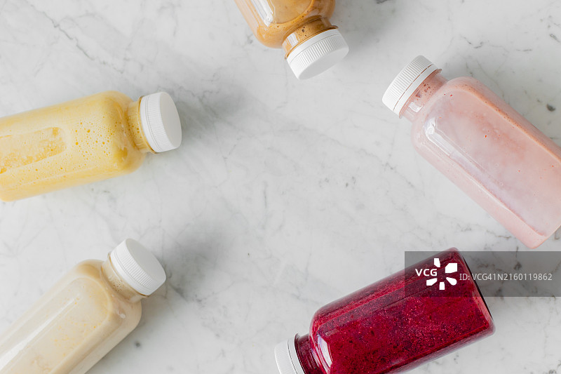 大理石桌上生态塑料瓶装浆果水果冰沙饮品图片素材