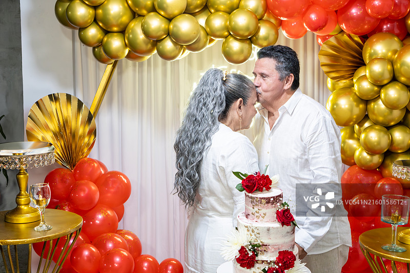 老年夫妇用亲吻和气球庆祝结婚纪念日图片素材