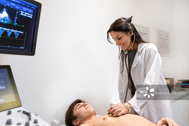 心脏科医生用听诊器听患者的心跳图片素材