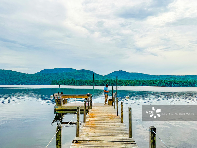男子和女儿在蓝山湖码头尽头钓鱼图片素材