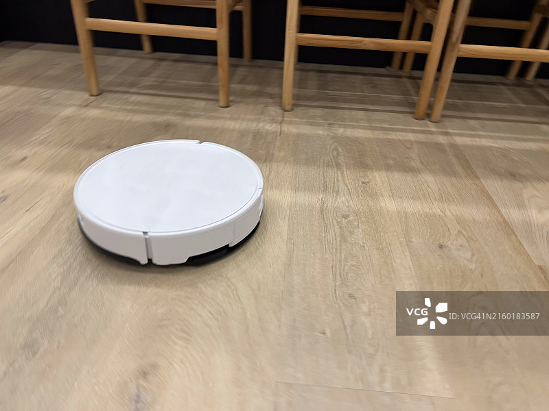 机器人吸尘器在地板上进行清洁图片素材