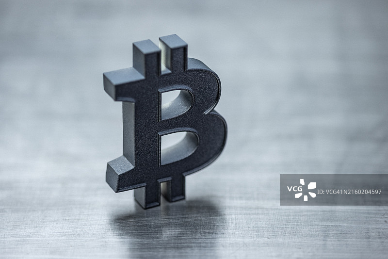 数字钱包和加密货币概念，数字货币和区块链技术，钢背景上的钛比特币图标，具有复制空间的简约设置，用深色石墨金属漆绘制的元素图片素材