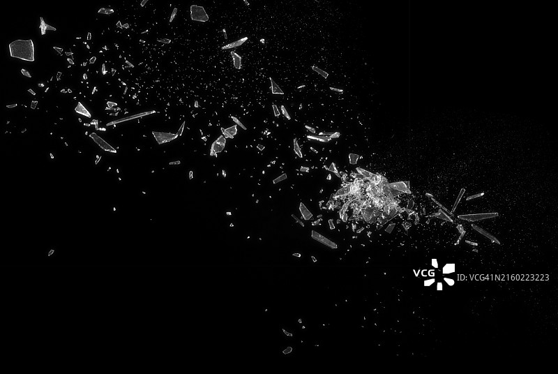 黑色背景上的破碎玻璃，展示了破碎玻璃的抽象纹理细节，该图像非常适合用于背景、纹理或抽象艺术项目图片素材