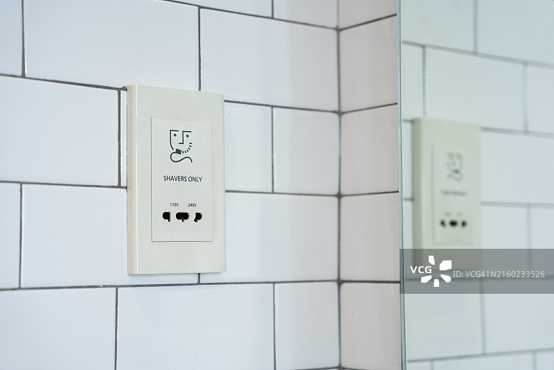 瓷砖墙上的以太网和电源插座图片素材