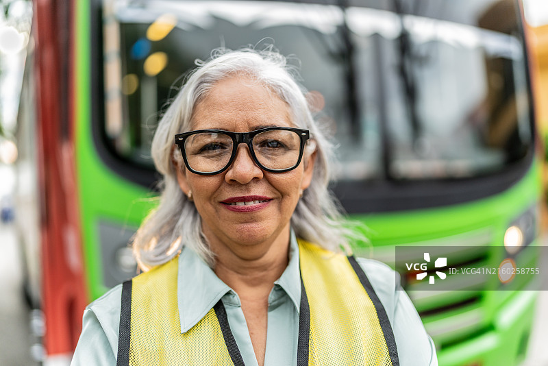 公交车前方的年长女公交车司机肖像图片素材