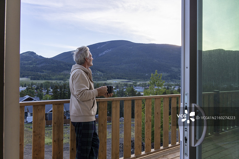 年长的男人在阳台上喝着热饮放松图片素材