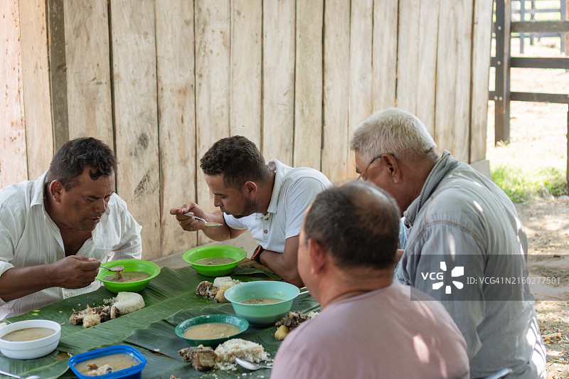 男士们一起享用传统户外美食图片素材