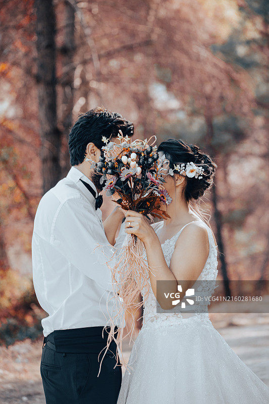 婚礼夫妇在自然中牵手亲吻的特写图片素材