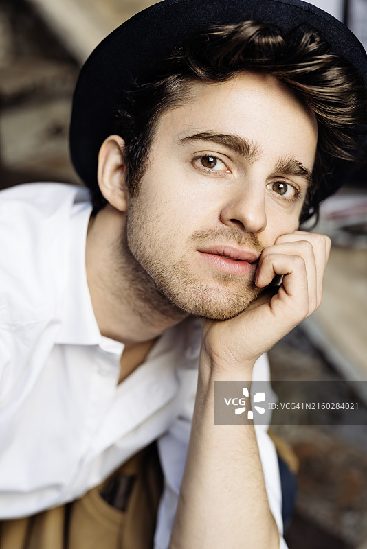 戴黑色帽子和白色衬衫的年轻英俊男人图片素材