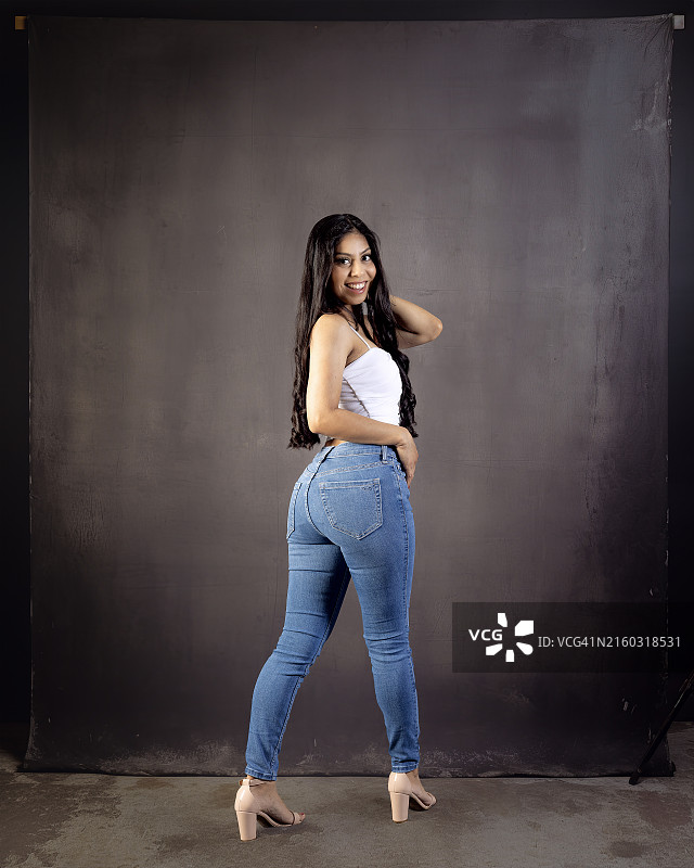 墙边站立的年轻女性肖像，美国加利福尼亚州贝克斯菲尔德图片素材