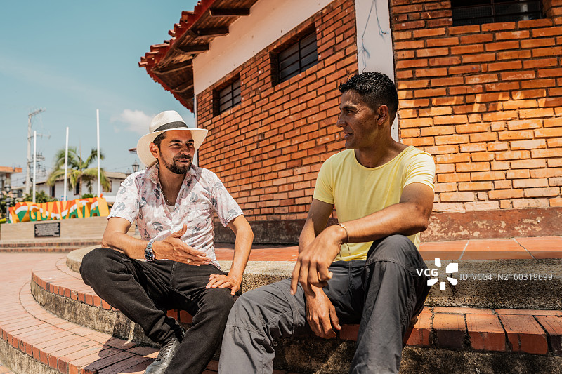 坐在户外台阶上交谈的中年朋友图片素材