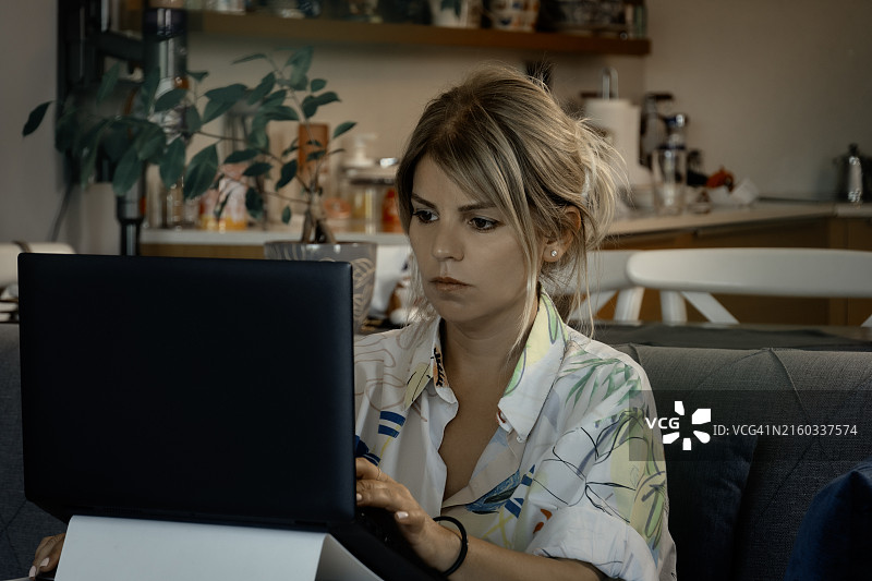在家用笔记本电脑工作的年轻白人女性图片素材