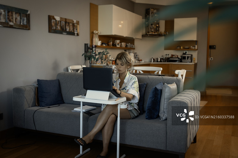 在家用笔记本电脑工作的年轻白人女性图片素材