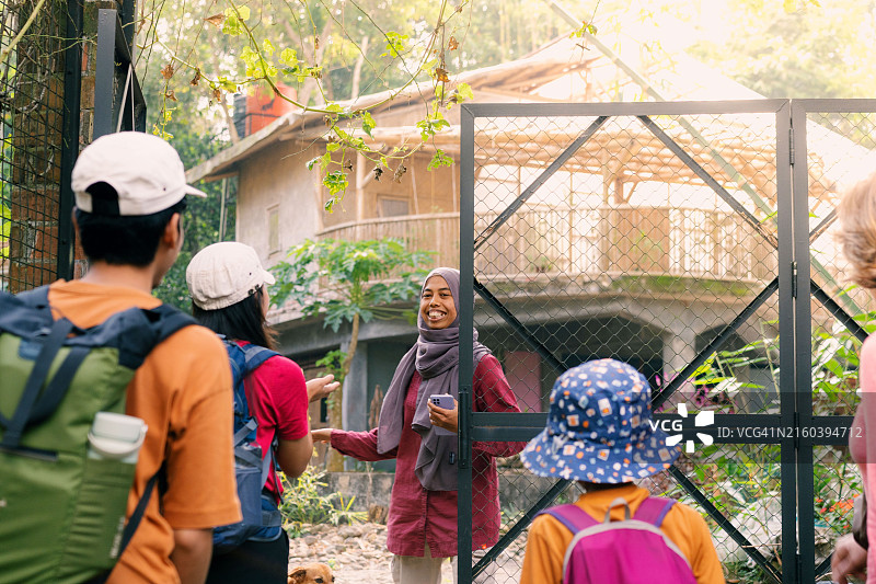 竹制民宿，穆斯林房主在门口热情迎接旅客图片素材