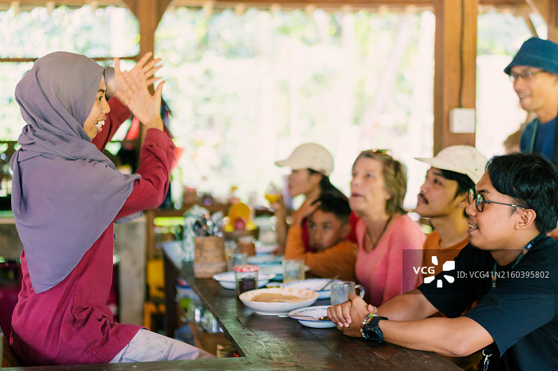 穆斯林女招待在客人享用小吃时讲故事图片素材