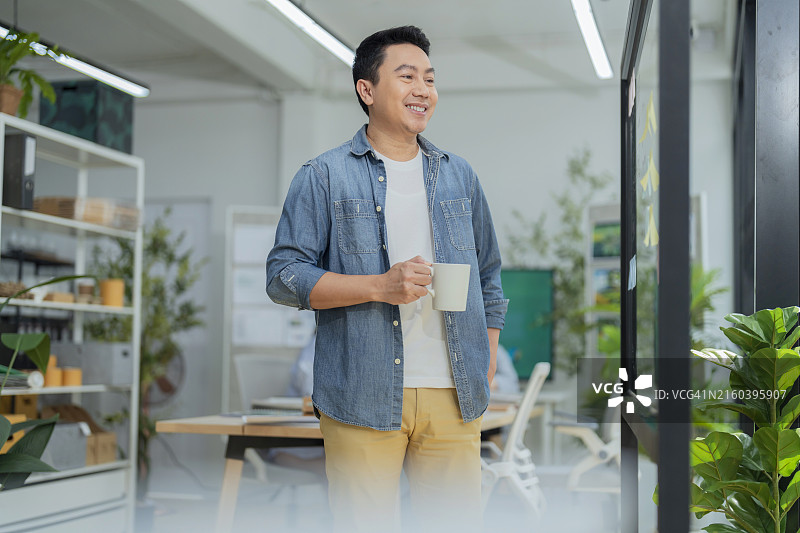 笑容满面、自信的亚洲商业领袖，双臂交叉看着镜头。鼓舞人心的亚洲商业男性领导者图片素材