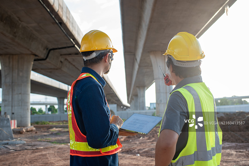在道路施工现场，土木工程师监督和检查道路建设图片素材
